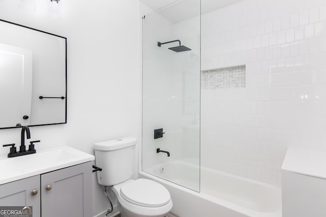 full bathroom with vanity, tiled shower / bath combo, and toilet