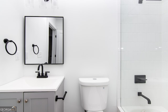 full bathroom with vanity, tiled shower / bath combo, and toilet