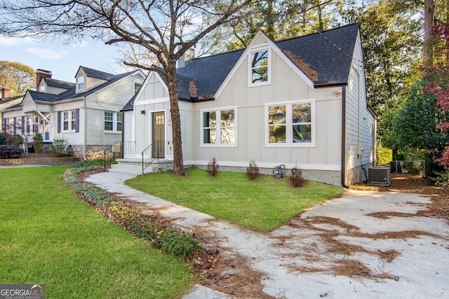 view of front of house with central air condition unit and a front yard