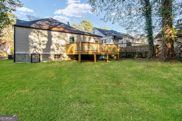 rear view of house with central AC unit, a deck, and a yard