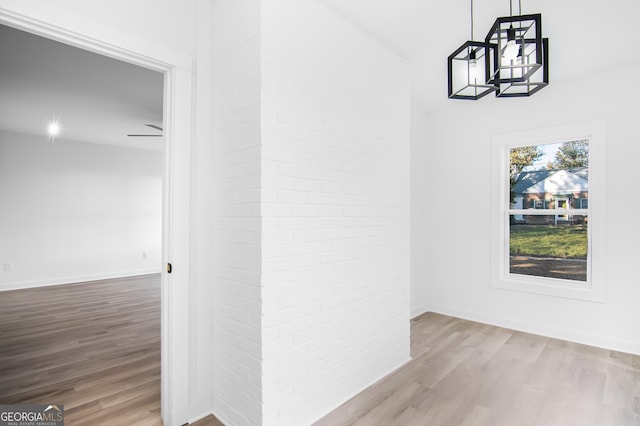 corridor with hardwood / wood-style flooring and a notable chandelier