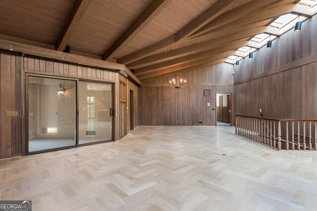 unfurnished room with beam ceiling, wooden walls, an inviting chandelier, light parquet flooring, and high vaulted ceiling