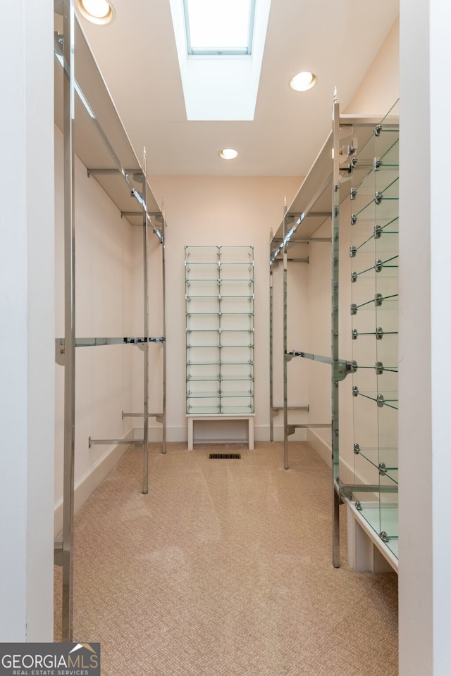 walk in closet with a skylight and carpet flooring