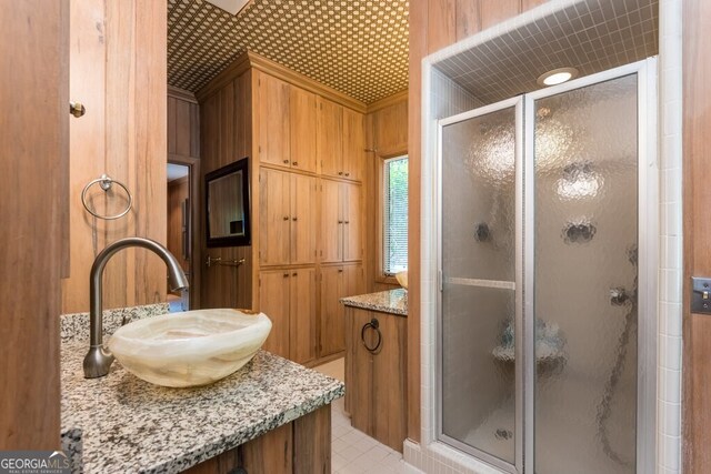 bathroom featuring a shower with door, vanity, and ornamental molding