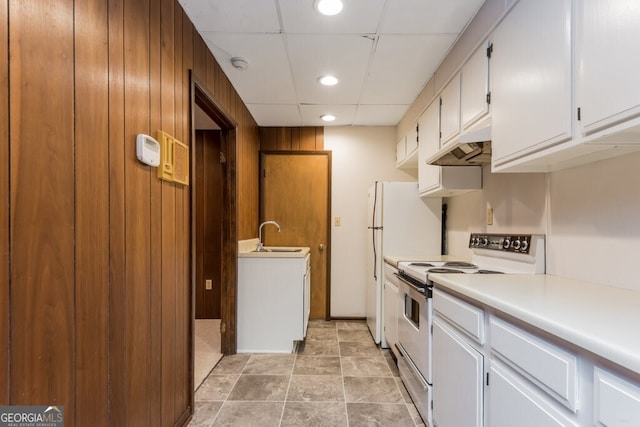 kitchen with wooden walls, white cabinetry, custom exhaust hood, and white appliances