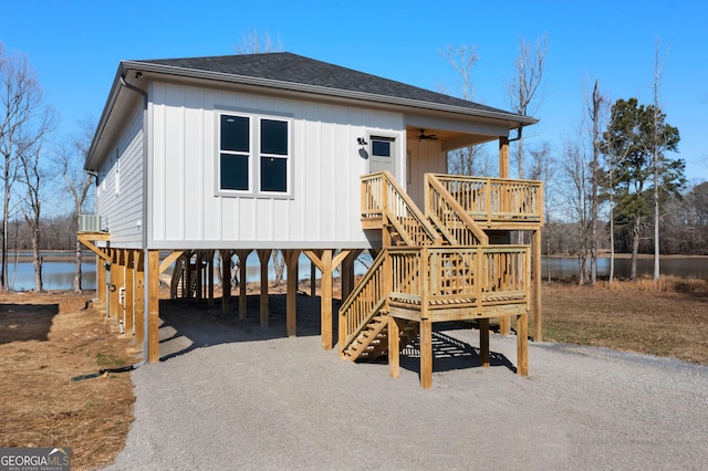 view of front of home with a carport, a shingled roof, driveway, and stairs