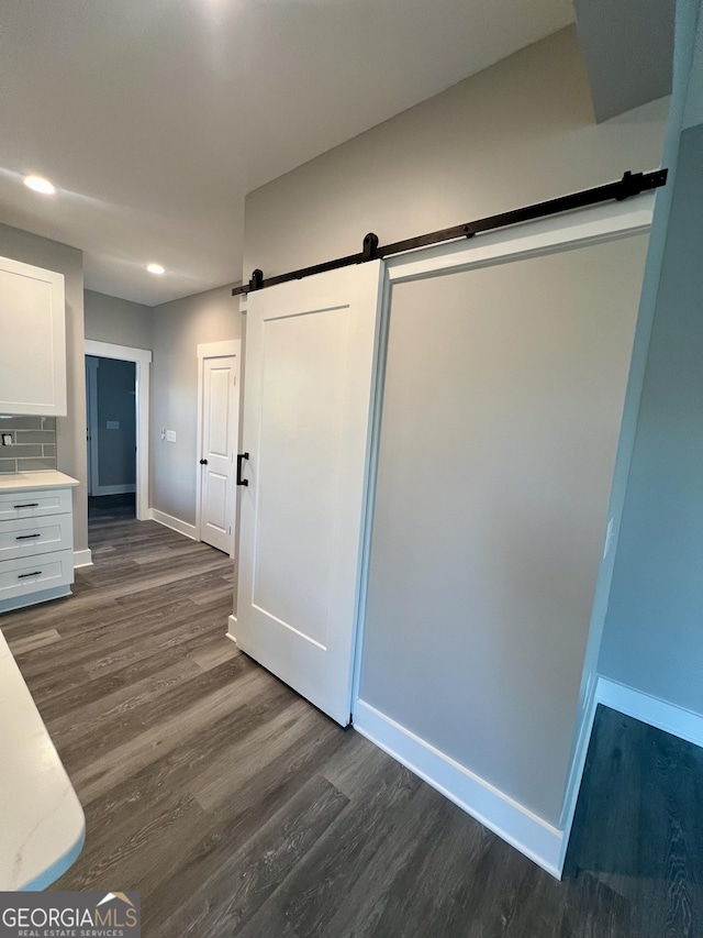 interior space with dark hardwood / wood-style flooring and a barn door