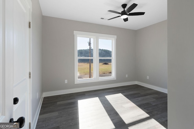 empty room featuring ceiling fan, visible vents, baseboards, and dark wood-style flooring