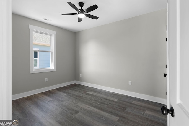 spare room with a ceiling fan, visible vents, baseboards, and dark wood-style flooring