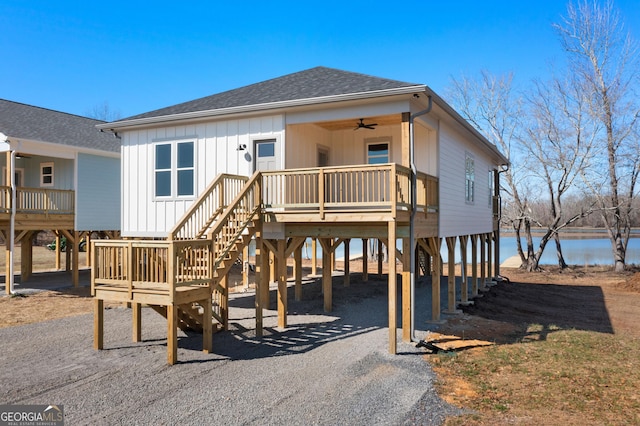 exterior space featuring roof with shingles, stairway, a ceiling fan, a carport, and driveway