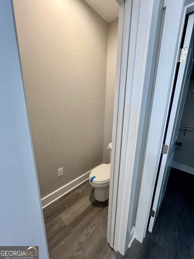 bathroom with wood-type flooring and toilet