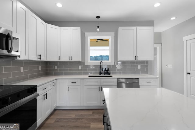 kitchen featuring white cabinets, decorative backsplash, stainless steel appliances, and a sink