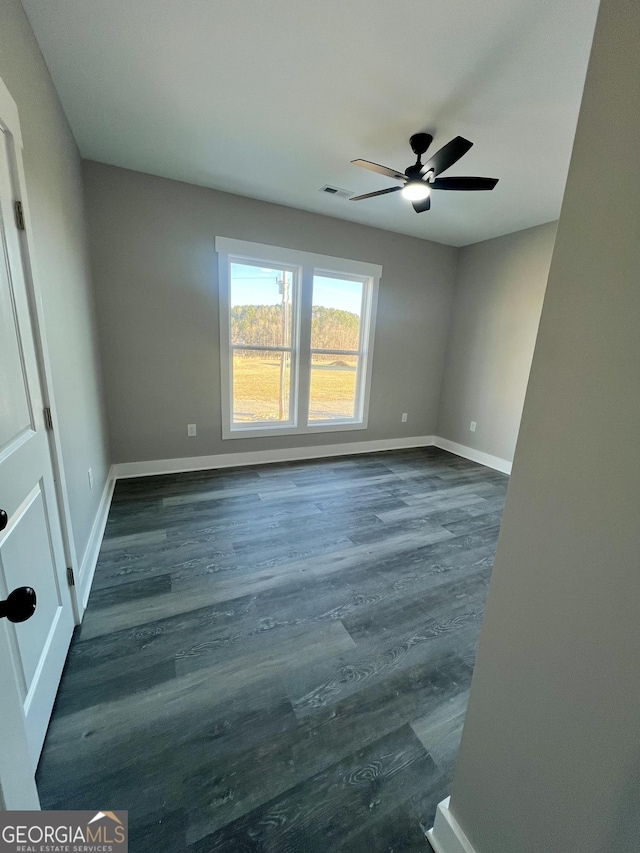 spare room featuring ceiling fan and dark wood-type flooring