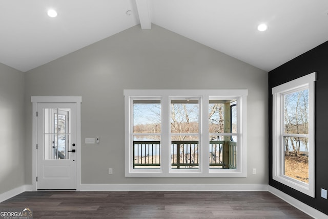 foyer entrance featuring lofted ceiling with beams, plenty of natural light, and dark wood-type flooring