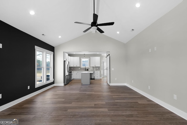 unfurnished living room with baseboards, dark wood finished floors, a ceiling fan, high vaulted ceiling, and recessed lighting