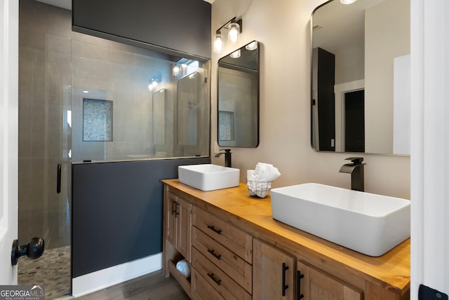 full bath featuring double vanity, a shower stall, and a sink