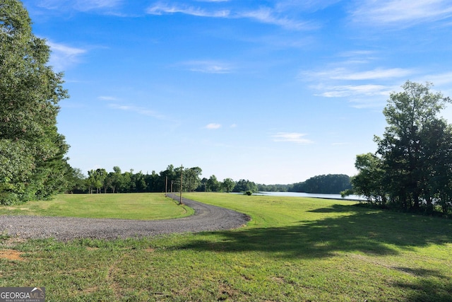 surrounding community featuring a water view and a yard