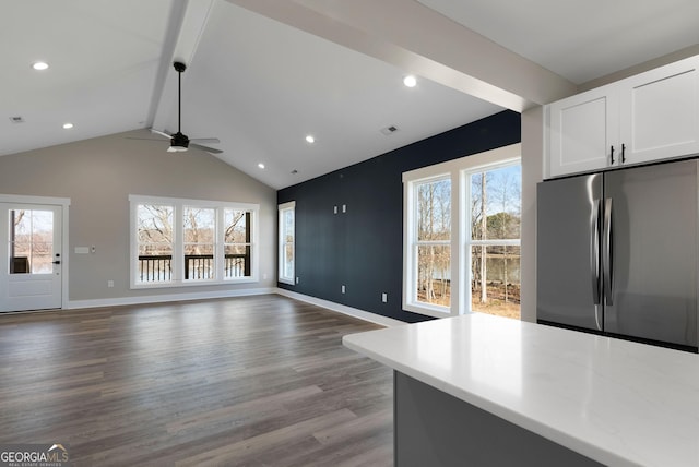 unfurnished living room featuring recessed lighting, visible vents, lofted ceiling with beams, wood finished floors, and baseboards