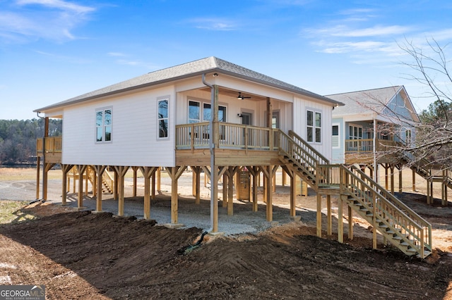 rear view of property featuring driveway, a shingled roof, stairway, and a carport