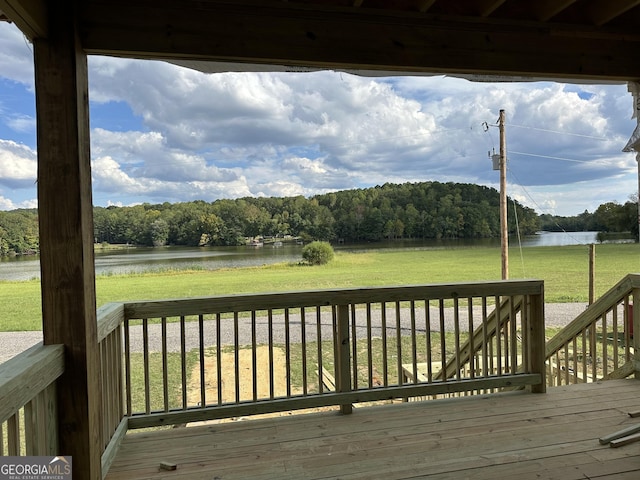 wooden terrace featuring a lawn and a water view