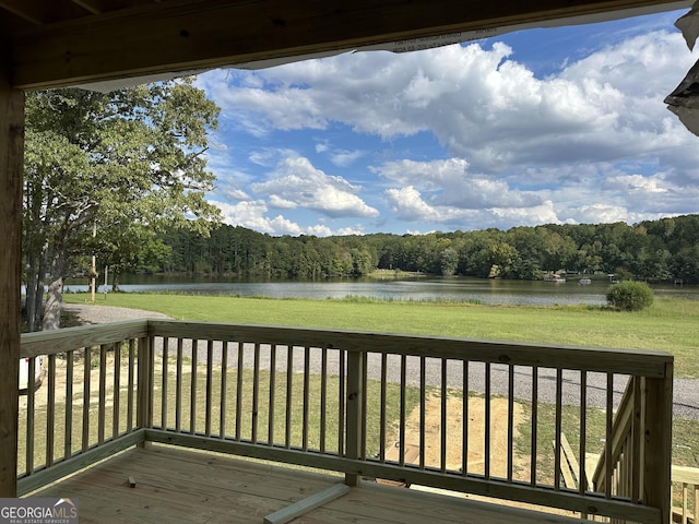 deck with a water view and a yard