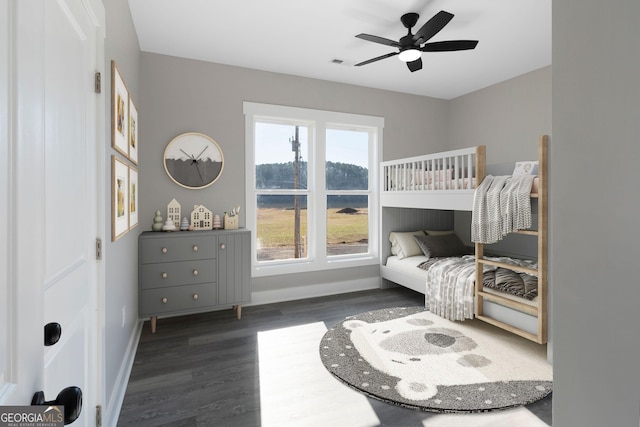 bedroom featuring a ceiling fan, visible vents, baseboards, and wood finished floors