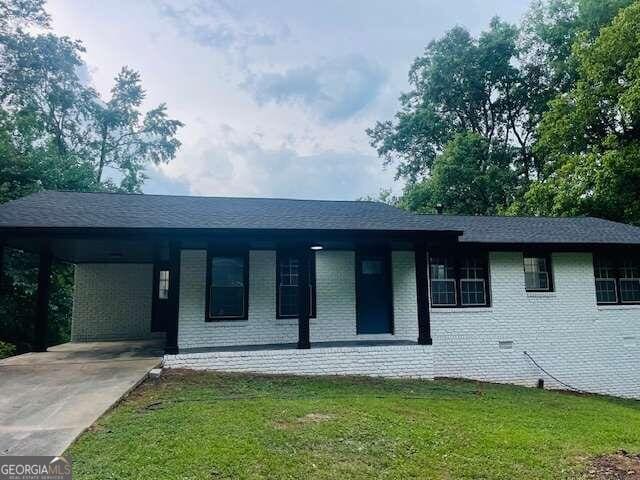 single story home with a carport and a front lawn