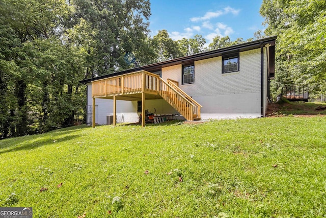 rear view of property featuring central air condition unit and a lawn