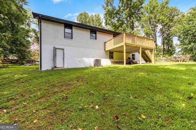 rear view of house featuring a wooden deck and a yard