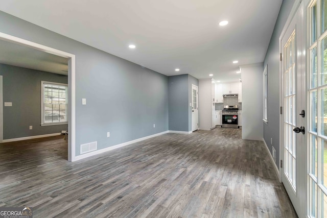 unfurnished living room featuring dark hardwood / wood-style flooring and french doors