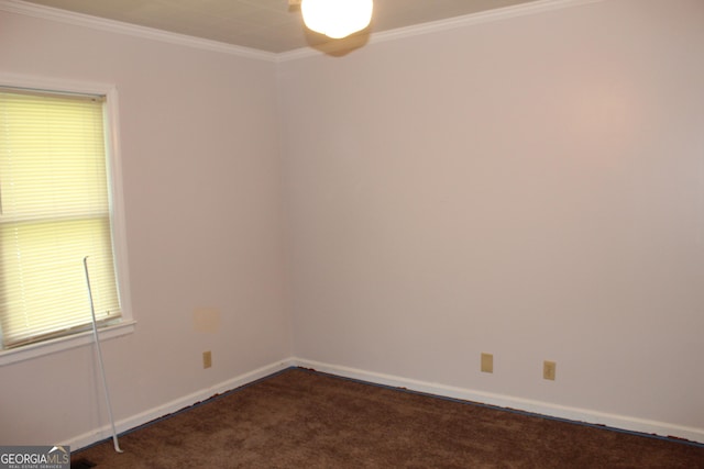 empty room featuring ornamental molding and dark colored carpet