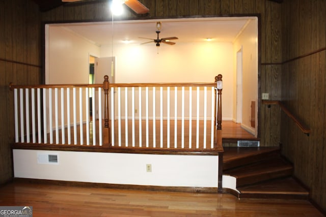 stairway featuring hardwood / wood-style flooring, ornamental molding, and ceiling fan