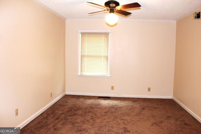 empty room featuring dark carpet, ornamental molding, ceiling fan, and a textured ceiling