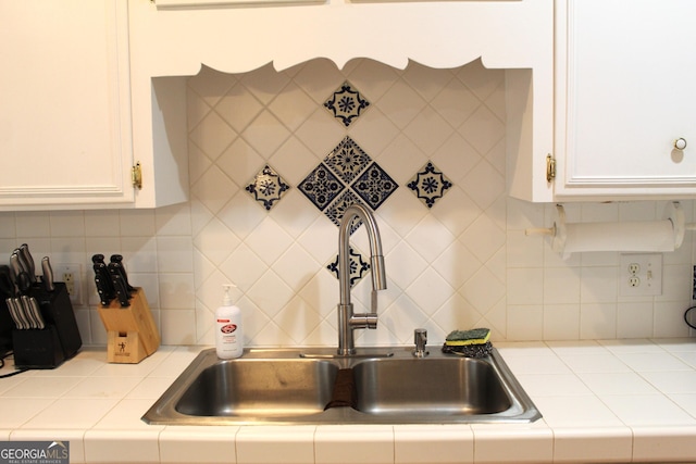 kitchen with white cabinetry, sink, and backsplash