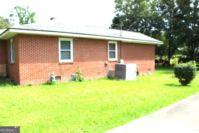 view of home's exterior featuring central AC unit and a lawn