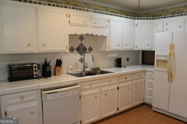 kitchen with tasteful backsplash, white cabinetry, sink, light hardwood / wood-style floors, and white appliances