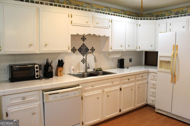 kitchen with white cabinetry, backsplash, and white appliances