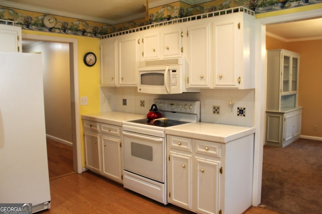 kitchen with white cabinetry, white appliances, and decorative backsplash