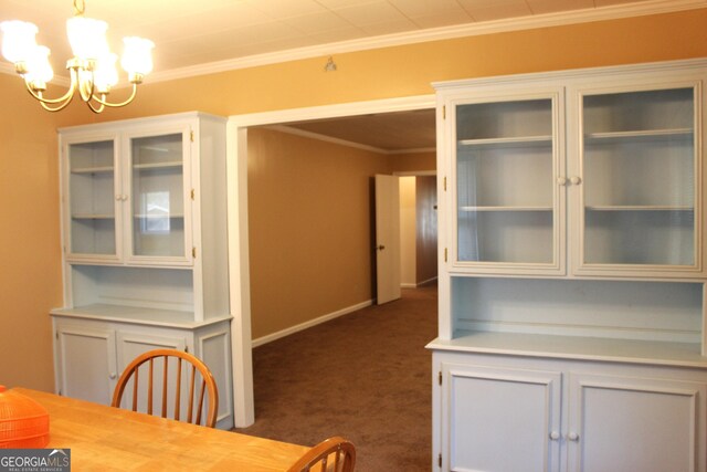 carpeted empty room with an inviting chandelier and ornamental molding