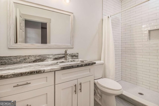 bathroom with curtained shower, vanity, and toilet