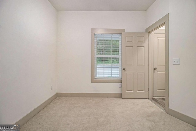 spare room featuring light colored carpet