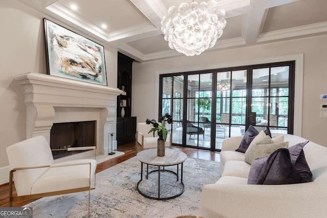 living room with coffered ceiling, wood-type flooring, beamed ceiling, ornamental molding, and an inviting chandelier