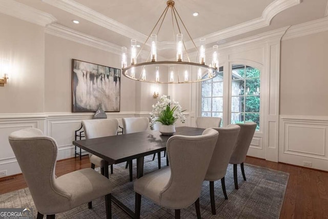 dining area with an inviting chandelier, crown molding, and hardwood / wood-style floors