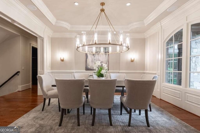 dining area with dark wood-type flooring, a notable chandelier, and ornamental molding