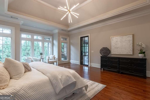 bedroom with ornamental molding, dark hardwood / wood-style flooring, multiple windows, and a tray ceiling