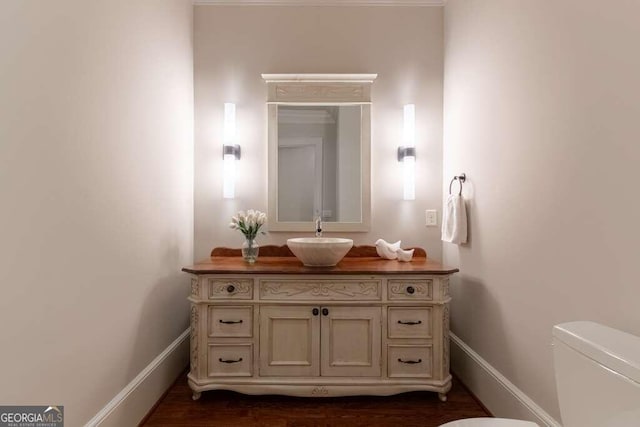 bathroom with hardwood / wood-style floors, vanity, and toilet