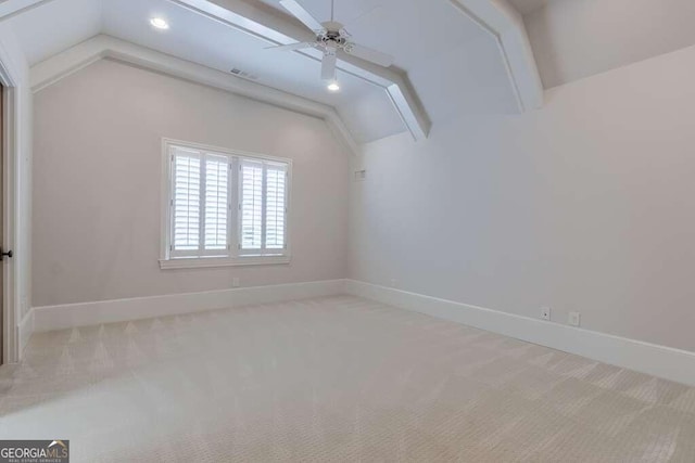 carpeted spare room with ceiling fan and vaulted ceiling