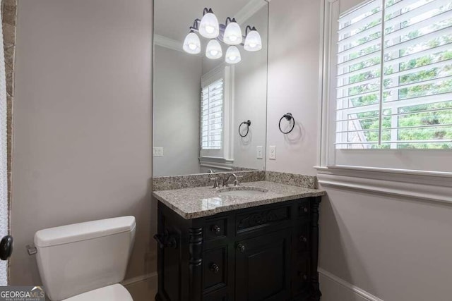 bathroom featuring a healthy amount of sunlight, crown molding, vanity, and toilet