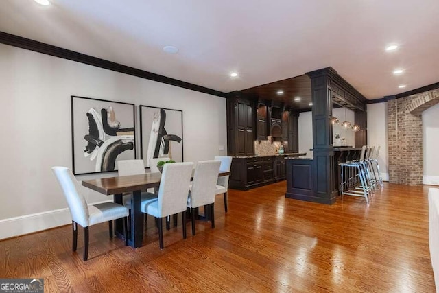 dining space with ornamental molding and hardwood / wood-style flooring