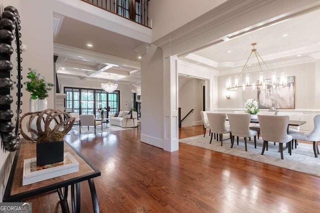 interior space with beam ceiling, coffered ceiling, crown molding, and wood-type flooring